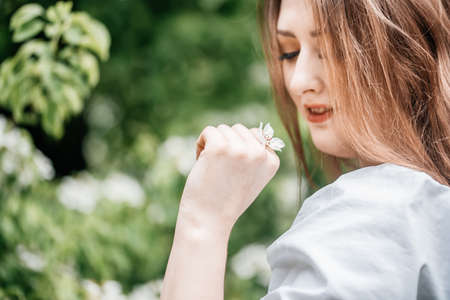 beautiful young woman in blooming cherry blossoms garden. bud in hair, lifestyleの写真素材