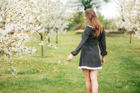 beautiful girl walking in the Park. Blooming apple trees in springの写真素材