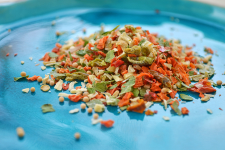 Spices 10 different vegetables on a shiny blue plateの写真素材