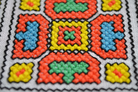 Geometric multi-colored pattern on white fabric embroidery, top viewの写真素材