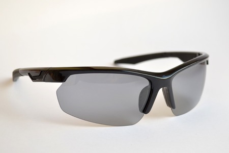 Sport black sunglasses with photochromic and polarizing effect on a white backgroundの写真素材