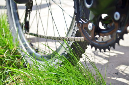New chain and new transmission on an old grey bicycle that stands on the grass, bottom view of the...