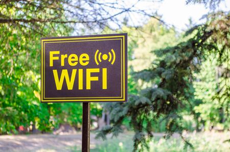 Free Wi-Fi tablet in yellow letters on a black background in a park on the streetの写真素材