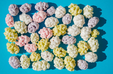 Sugar drops in the form of clouds, lie in a blue background in the shape of a rectangle