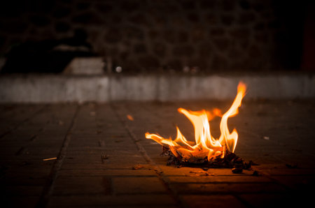 Paper book burns to ashes on concrete tiles, manuscript burns, open book with burning fireの写真素材