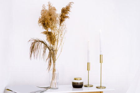 Dressing table, in white bedroom with candles, a vase with plants and magazinesの写真素材