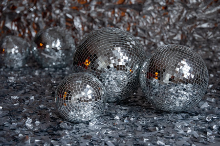 Silver disco balls lie on surface covered with silver foil, all shining together, photo zoneの写真素材