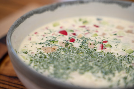 Traditional eastern European cold soup okroshka served on a wooden board. Fresh summer dish made...