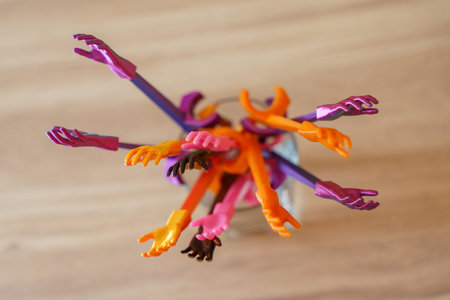 Colorful miniature plastic hands created with 3D printing technology raised upward together. Concept of participation, voting, teamwork, diversity or asking a question.の写真素材