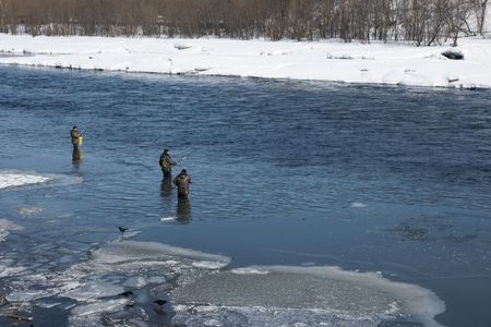 Fishermen go fishing on river during high water by springtime.の写真素材