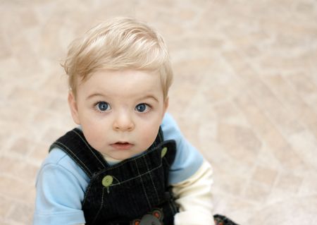 blond child intently peers into cameraの写真素材