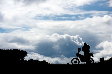 silhouette men near motorcycle on background of the skyの写真素材
