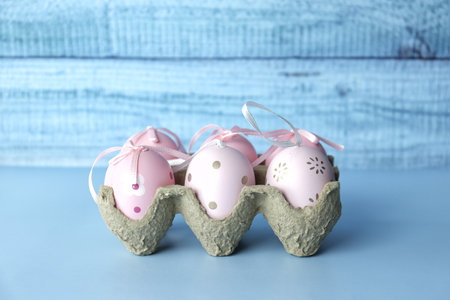 Easter eggs with silk ribbons on a blue monochromatic backgroundの写真素材