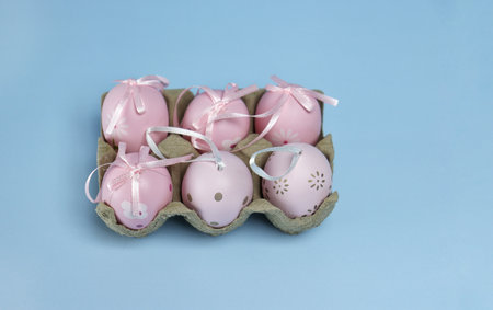 Easter eggs with silk ribbons on a blue monochromatic backgroundの写真素材