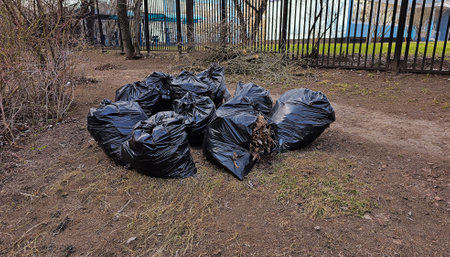 Plastic black bags of garbage lie on the groundの写真素材