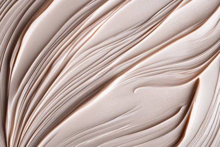 Smooth beige cream texture with elegant flowing lines, cosmetic background showcasing skincare luxury, softness, hydration and minimal beauty conceptの素材