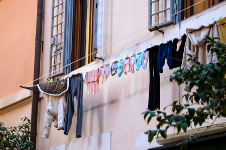 Hanging clothes to dry on the line below window and old grungy wall of house in Rome Italy..の写真素材