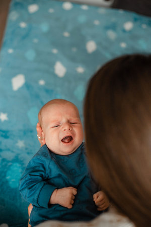 Newborn baby boy and his mother on the bed in the roomの写真素材