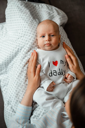 Mother holding her cute baby boy on the bed. top view.の写真素材