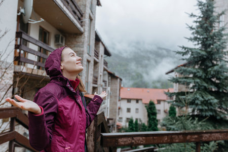 Young woman in a raincoat in the mountains. rainy weather.の写真素材