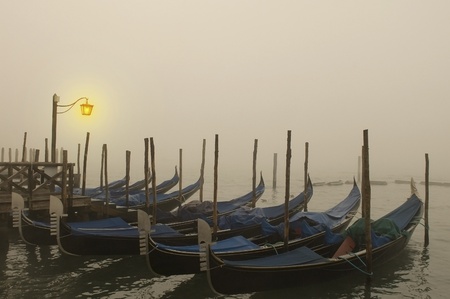 Venetian gondolas are sleeping in the night fogの写真素材