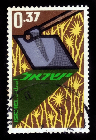 ISRAEL - CIRCA 1963: A stamp printed in Israel, shows a hoe clearing a field of thistles,  in honor of Year of the Pioneers, circa 1963のeditorial素材
