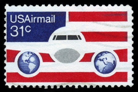 UNITED STATES OF AMERICA - CIRCA 1976  a stamp printed in the USA shows image of an aeroplane, two hemispheres of the globe on the background of the American flag, circa 1976の写真素材