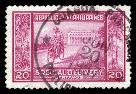 PHILIPPINES - CIRCA 1947  a stamp printed in Philippines shows Manila Post Office and postman on a bike, circa 1947のeditorial素材