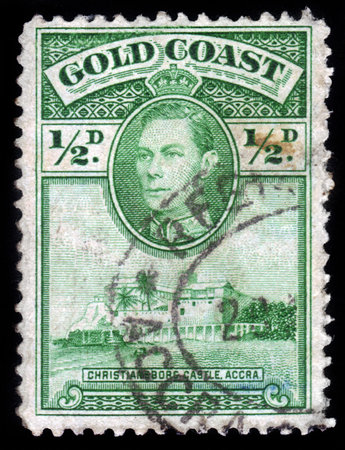 GOLD COAST - CIRCA 1938: A stam printed in British colony Gold Coast (now Ghana) shows Christiansborg Castle Accra and King George VI, green, circa 1938のeditorial素材