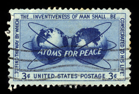 UNITED STATES OF AMERICA - CIRCA 1955: a stamp printed in USA, shows atomic energy encircling the hemispheres, atoms for peace Issue, circa 1955のeditorial素材