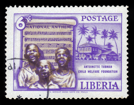 LIBERIA - CIRCA 1957: a stamp printed in the Liberia shows children sing the national anthem, founding of the Antoinette Tubman child welfare foundation, circa 1957のeditorial素材