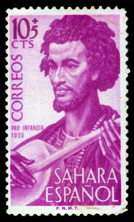 SPANISH SAHARA - CIRCA 1953: stamp printed by Spain, shows man musician, issue to benefit the children welfare fund, red, circa 1953のeditorial素材