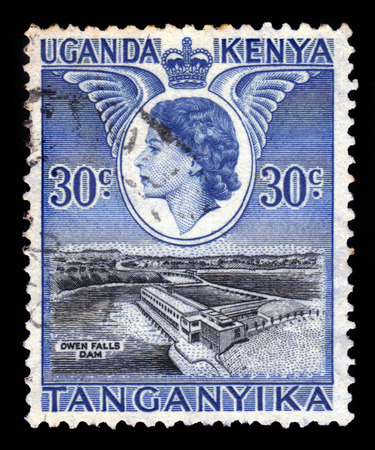 Kenya Uganda Tanganyika - CIRCA 1954: a stamp printed in United Kingdom shows Queen Elizabeth II and  Owen Falls Dam, circa 1954のeditorial素材