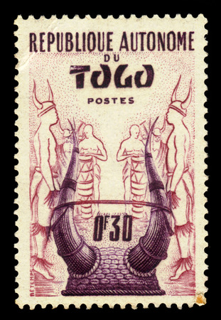 Togo - CIRCA 1957: A stamp printed in Togo shows togo traditional headdress, circa 1957のeditorial素材