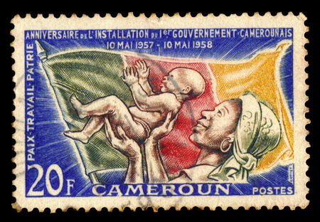 Cameroon - CIRCA 1958: A stamp printed in Cameroon shows woman and child, flag of Cameroon, circa 1958のeditorial素材