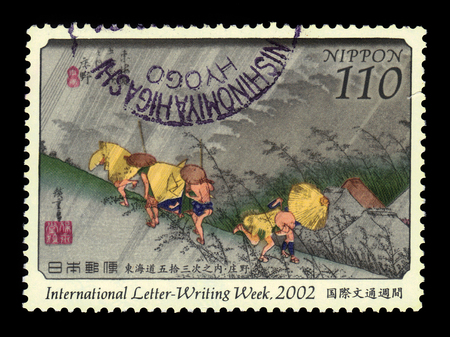 JAPAN - CIRCA 2002: A stamp printed in Japan shows travellers surprised by sudden rain, painting by Utagawa Hiroshige, international letter-writing week 2002, circa 2002のeditorial素材