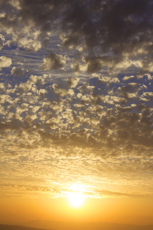 beautiful sunset, the sun illuminates the clouds of golden colorの写真素材