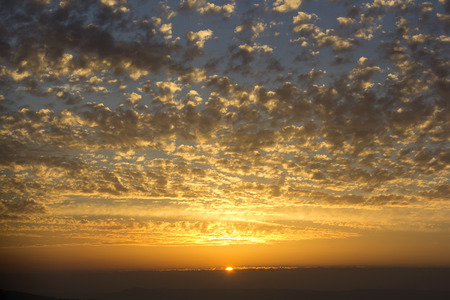 beautiful sunset, the sun illuminates the clouds of golden colorの写真素材