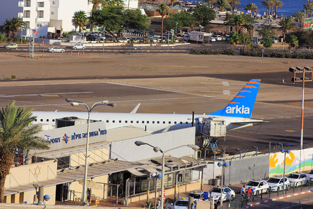 Eilat, Israel - MAY 24: plane of israeli airline Arkia, landed at the airport of Eilat on the background of luxurious hotels, Israel, on May 24, 2017 in  Eilat, Israelのeditorial素材