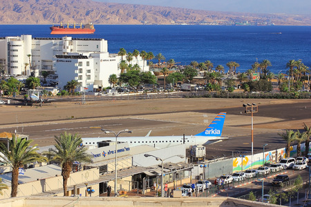 Eilat, Israel - MAY 24: plane of israeli airline Arkia, landed at the airport of Eilat on the background of luxurious hotels, Israel, on May 24, 2017 in  Eilat, Israelのeditorial素材