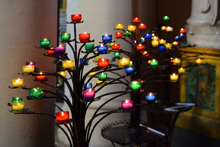 colored burning memorial candles in the churchの写真素材