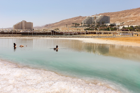 Dead Sea, Ein Bokek, Israel - March 18: vacationers and tourists bathe in the Dead Sea on the background of luxury hotels on March 18, 2018のeditorial素材