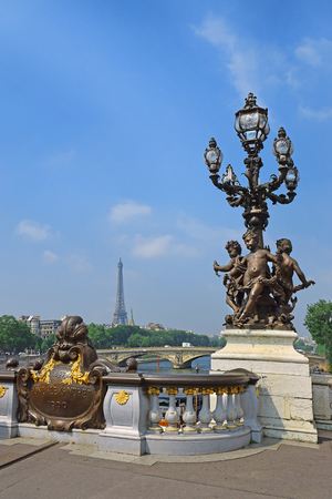 Pont Alexandre III bridge decorated with ornate Art Nouveau lamps and sculptures and Eiffel Tower in the distance, Paris, Franceのeditorial素材