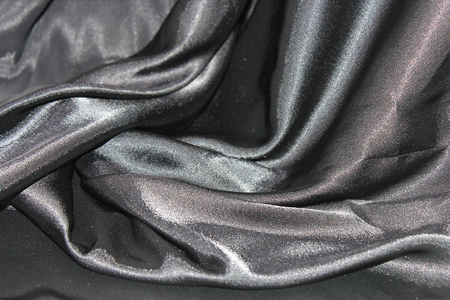 undulating folds of the fabric of gray silk as festive backgroundの写真素材