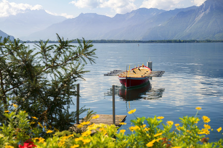 scenic landscape with rowing boat on the background of the Alps on the Lake Geneva, Switzerlandの写真素材