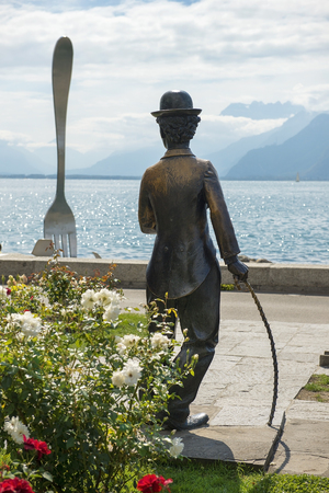 VEVEY, Switzerland - September 02: monument to Charlie Chaplin on the promenade in Vevey (Vaud) on the background giant fork sticking out of a Geneva lake, Switzerland on September 02, 2018のeditorial素材