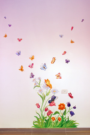colorful butterflies fly over flowers, drawing on the wall in the children's roomの写真素材