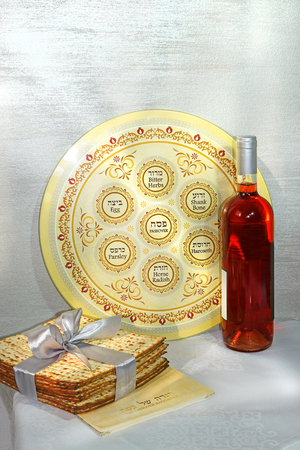 spring holiday of Passover and its attributes, with bottle of wine, seder plate, matzo and Haggadah in Hebrew - Happy Passoverの写真素材