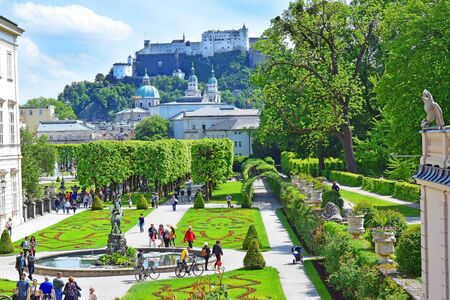 Salzburg, Austria - May 23, 2018 : people walk among flower beds in the Mirabell park in Salzburg, old historic Fortress Hohensalzburg in the backgroundのeditorial素材
