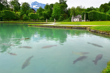 Salzburg, Austria - May 25, 2019 : pond with giant common carps and sculptures of a unicorn in the park of the Hellbrunn Palace - summer residence of the Archbishop of Salzburgのeditorial素材
